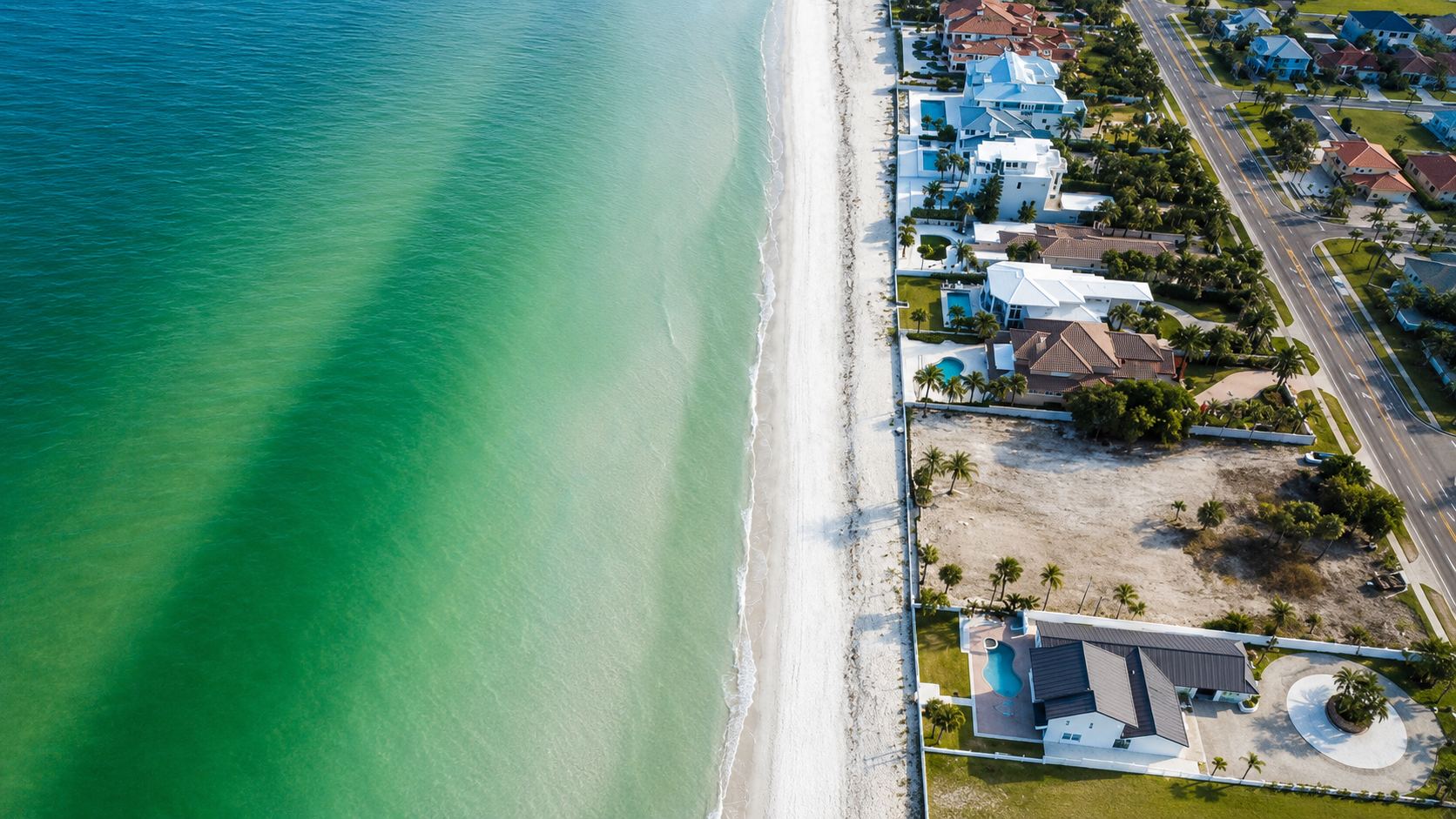 Aerial photograph of the cleared Gulf-front parcels on Gulf Boulevard in Belleair Shore, with emerald Gulf water and white sand beach